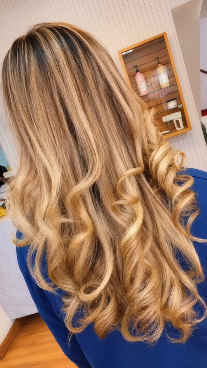 Cabelo longo com luzes douradas e ondas volumosas