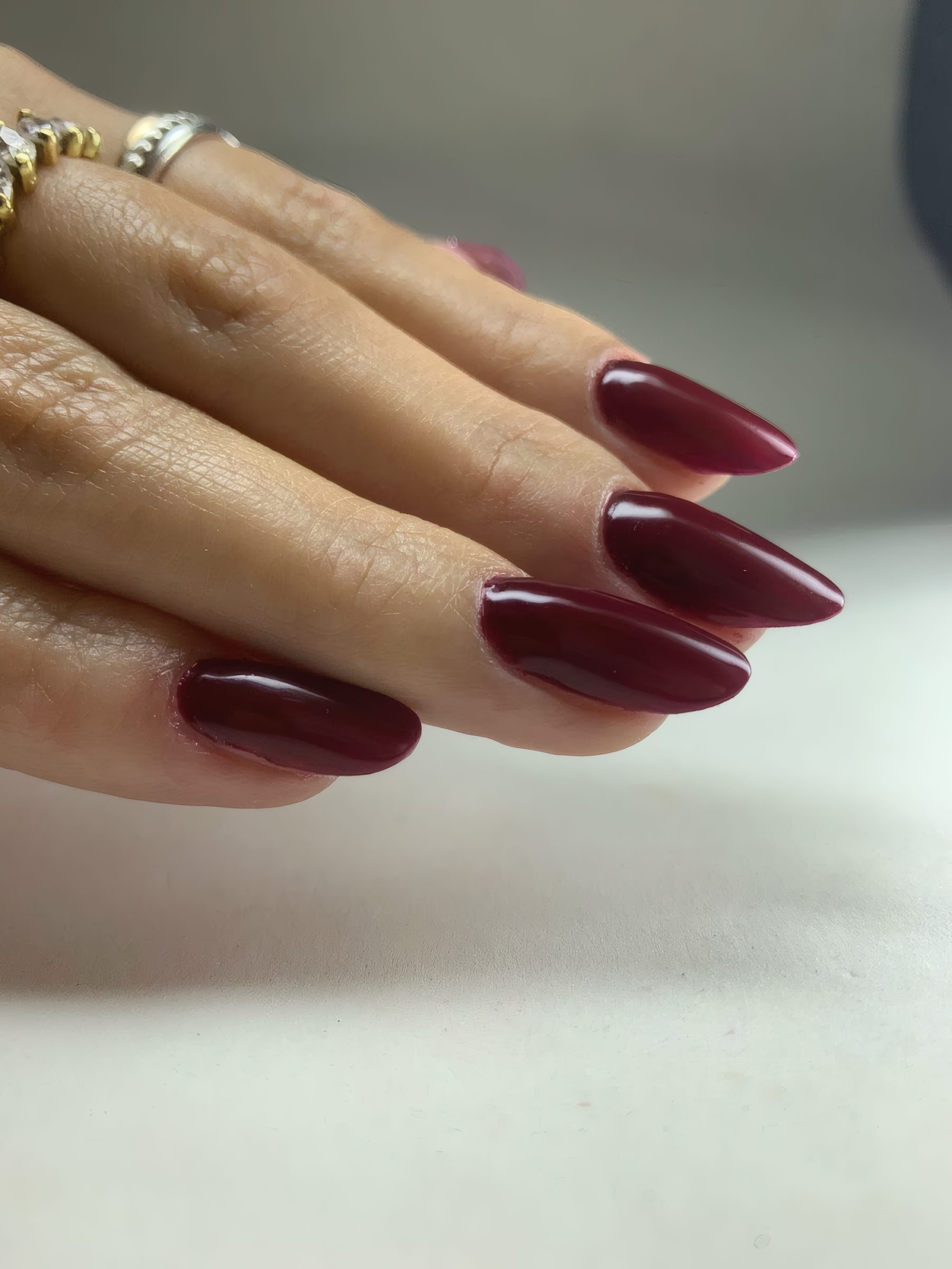 Unhas esmaltadas em vinho, alongadas e com acabamento brilhante